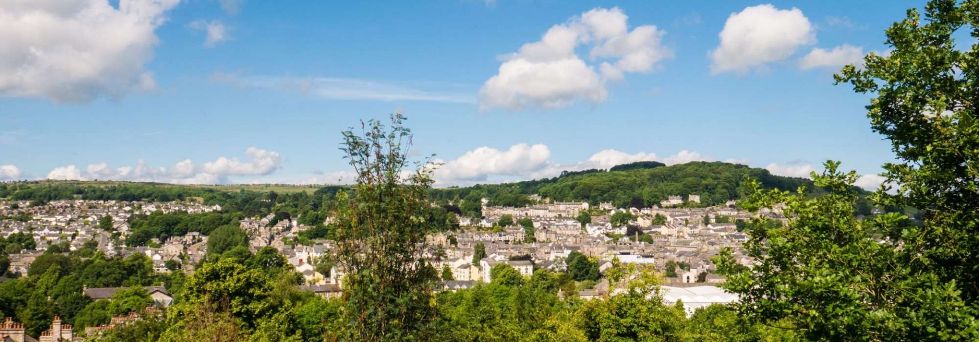 Far off shot of Kendal town from a distance, rooftops and landscape behind 