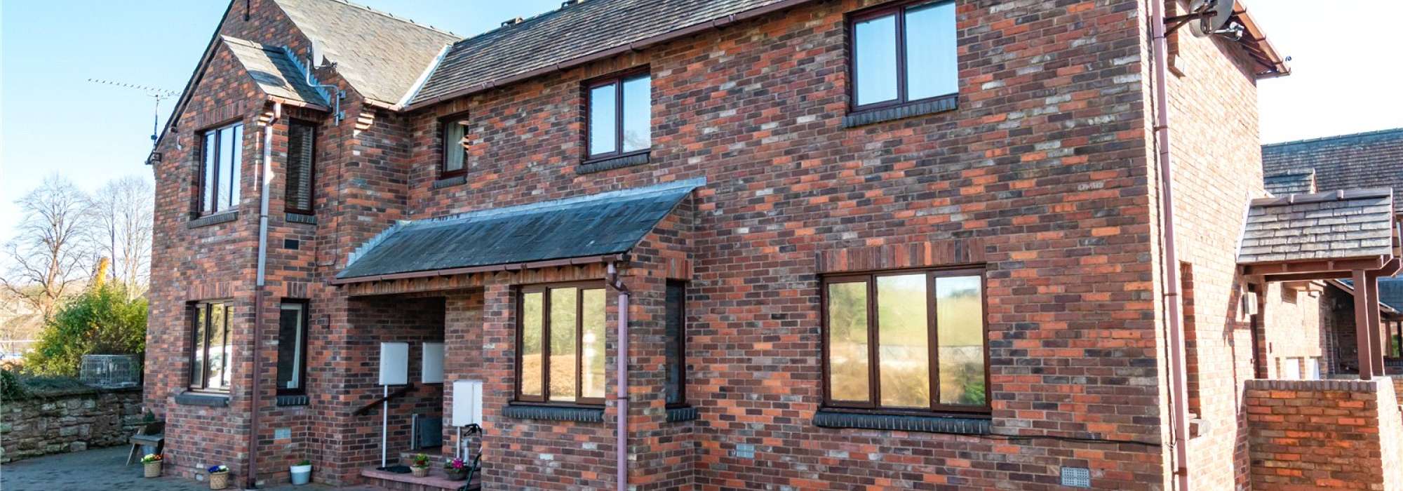 Brown brick house with driveway in the front.