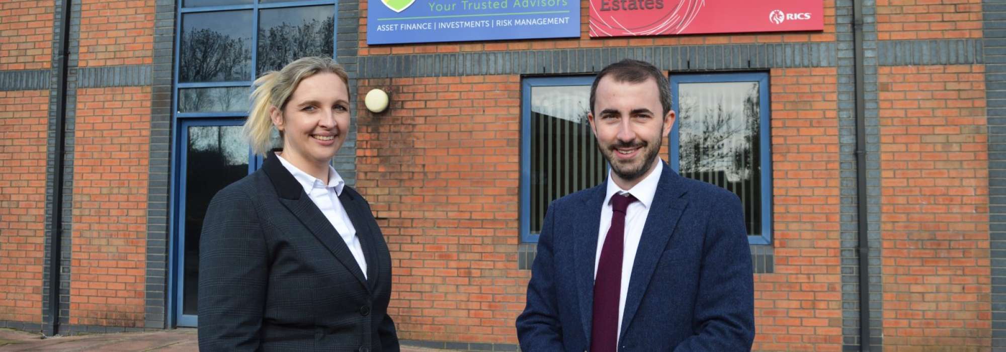 Corinne Cooper of H&H Insurance Brokers and Robert Jauneika of H&H Land & Estates stand proudly outside their new office building