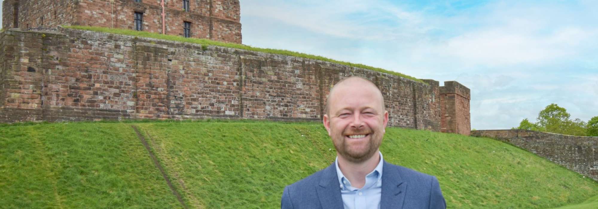 Man in a suit stood in front of the castle