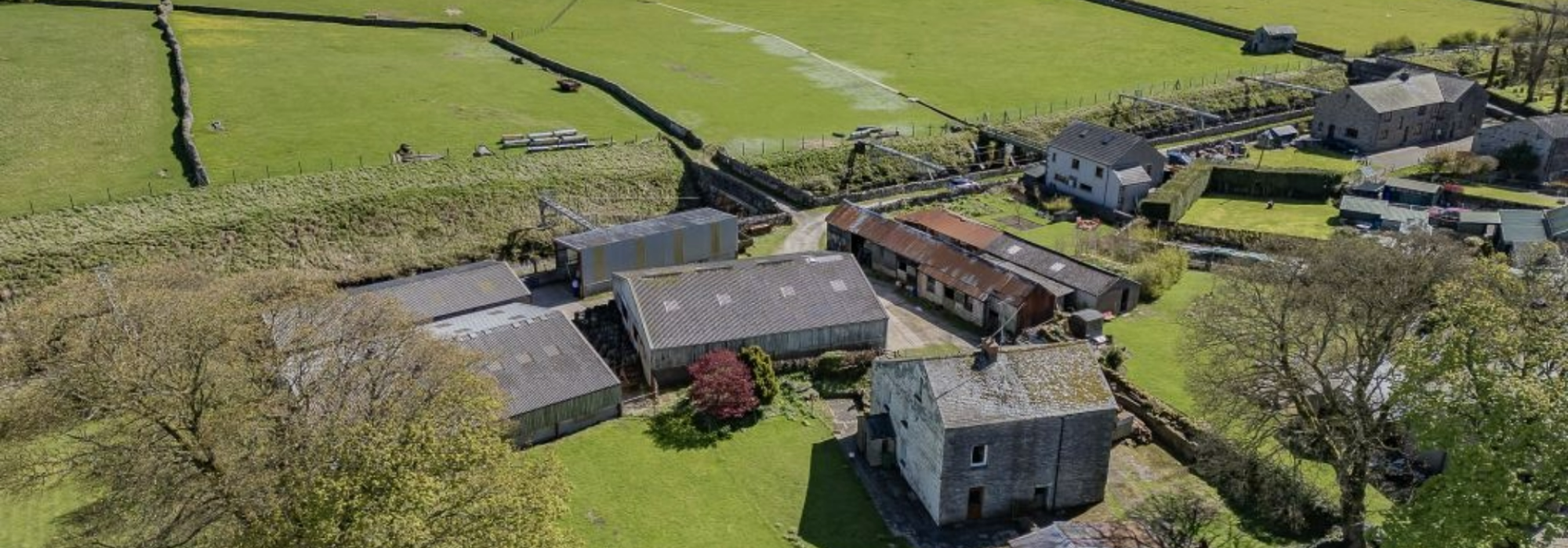 Large Farm with sheds and land and blue skies.